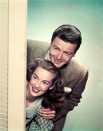 1950s SMILING COUPLE PEEKING AROUND CORNER OF DOOR Stock Photo - Rights-Managed, Code: 846-05647876