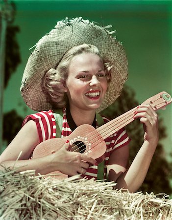 1940s - 1950s SMILING BLOND WOMAN WEARING STRAW HAT SITTING ON HAY PLAYING UKULELE Stock Photo - Rights-Managed, Code: 846-05647879
