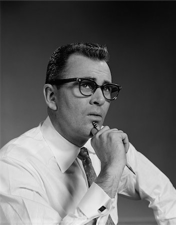 simsearch:846-08639518,k - 1960s MAN THINKING HAND PENCIL ON CHIN WEARING EYEGLASSES SERIOUS EXPRESSION Stock Photo - Rights-Managed, Code: 846-05647896