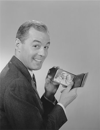 1950s - 1960s MAN SMILING HOLDING  WALLET SHOWING PHOTO OF FAMILY Stock Photo - Rights-Managed, Code: 846-05647893