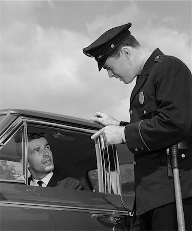 simsearch:846-05646032,k - 1960s POLICE OFFICER WARNING MOTORIST POINTING FINGER AT DRIVER Stock Photo - Rights-Managed, Code: 846-05647934