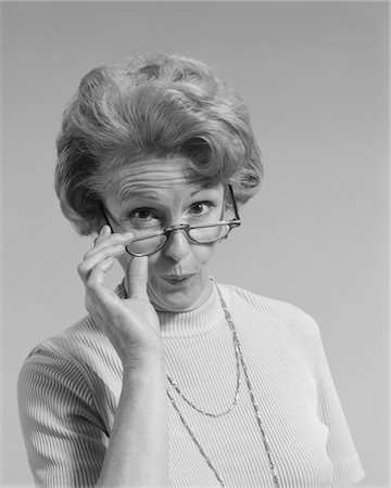 expresión facial - 1960s - 1970s MATURE WOMAN LOOKING OVER THE TOP OF HER EYEGLASSES FUNNY FACIAL EXPRESSION Foto de stock - Con derechos protegidos, Código: 846-05647947