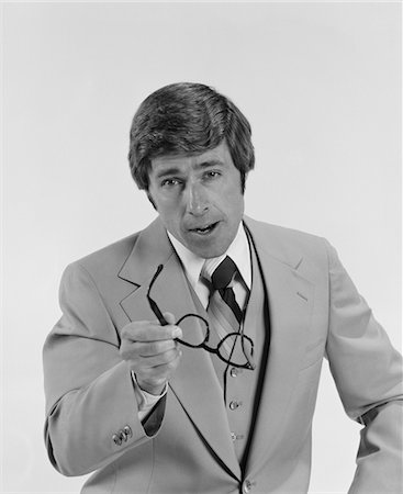 simsearch:846-05648291,k - 1970s BUSINESSMAN SERIOUS EXPRESSION POINTING WITH EYEGLASSES Stock Photo - Rights-Managed, Code: 846-05647951