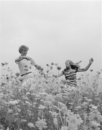 people running scared - 1970s YOUNG COUPLE HOLDING HANDS RUNNING THROUGH FIELD OF FLOWERS Stock Photo - Rights-Managed, Code: 846-05648067