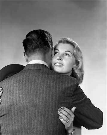 1950s - 1960s BLONDE WOMAN HUGGING MAN WITH HIS BACK TO THE CAMERA Stock Photo - Rights-Managed, Code: 846-05648091