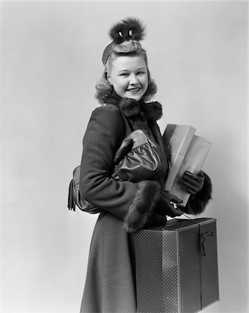 simsearch:846-05648541,k - 1940s - 1950s SMILING YOUNG BLOND WOMAN WEARING HAT FUR TRIMMED COAT CARRYING PACKAGES Stock Photo - Rights-Managed, Code: 846-05648101