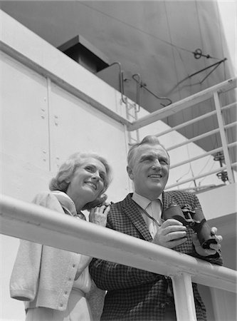 simsearch:846-05648112,k - 1960s SMILING MATURE COUPLE AT SHIPBOARD RAIL WITH BINOCULARS Stock Photo - Rights-Managed, Code: 846-05648155