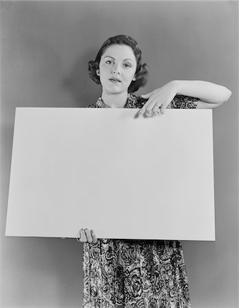 simsearch:846-05648290,k - 1930s - 1940s WOMAN HOLDING BLANK POSTER SIGN HAND POINTING FROM TOP Stock Photo - Rights-Managed, Code: 846-05648174