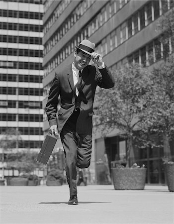 simsearch:846-02796426,k - 1960s BUSINESSMAN CARRYING BRIEFCASE HOLDING HIS HAT ON RUNNING DOWN URBAN SIDEWALK Stock Photo - Rights-Managed, Code: 846-05648198