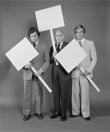 simsearch:846-05648291,k - 1970s TRIO OF BUSINESSMEN CARRYING BLANK SIGNS Stock Photo - Rights-Managed, Code: 846-05648295