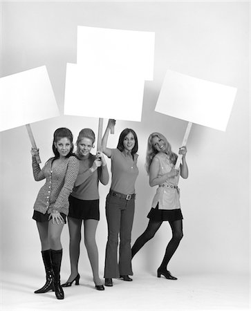 simsearch:846-02796457,k - 1970s FOUR YOUNG WOMEN WEARING MINISKIRTS AND FLARED JEANS CARRYING BLANK SIGNS Stock Photo - Rights-Managed, Code: 846-05648301