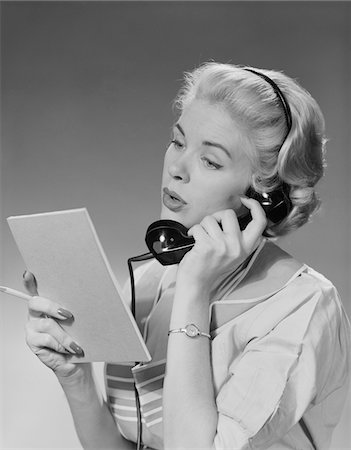 1950s - 1960s BLOND WOMAN TALKING ON TELEPHONE READING LIST Stock Photo - Rights-Managed, Code: 846-05648465