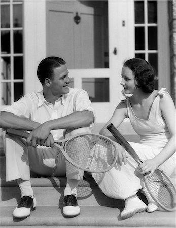 simsearch:846-05648202,k - 1930s COUPLE MAN WOMAN IN TENNIS WHITES HOLDING RACQUETS SITTING TALKING ON STEPS IN FRONT OF HOUSE OUTDOOR Stock Photo - Rights-Managed, Code: 846-05648468
