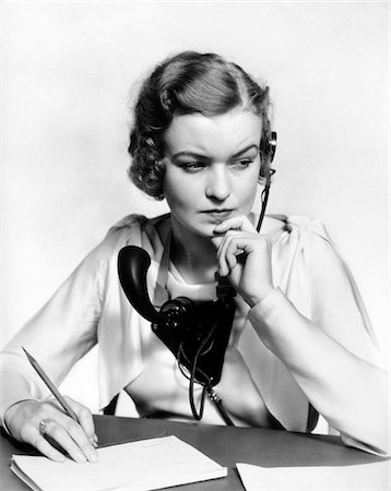 simsearch:846-08639518,k - 1930s PORTRAIT BUSINESS OFFICE WOMAN RECEPTIONIST WEARING HEADPHONES AND SPEAKER MICROPHONE LOOKING WORRIED AND CONCERNED Stock Photo - Rights-Managed, Code: 846-05648474