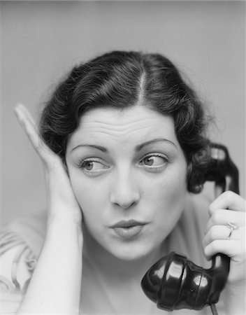 purse lips - 1930s YOUNG BRUNETTE WOMAN WITH SURPRISED EXPRESSION HAND TO HEAD TALKING ON TELEPHONE Stock Photo - Rights-Managed, Code: 846-05648472