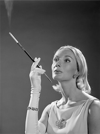 simsearch:846-02796457,k - 1960s PORTRAIT OF ELEGANT BLONDE WOMAN WEARING GOWN LONG WHITE GLOVES RHINESTONE JEWELRY WITH FRENCH CIGARETTE HOLDER Stock Photo - Rights-Managed, Code: 846-05648491