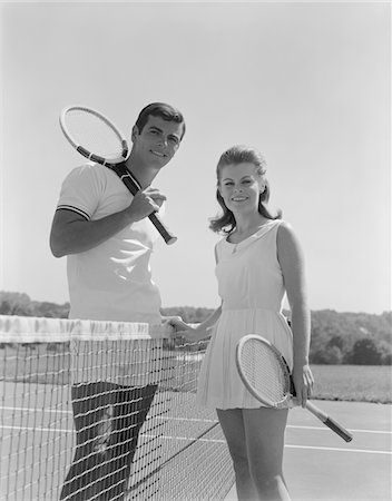 simsearch:846-05648202,k - 1960s PORTRAIT TENNIS COUPLE MAN WOMAN HOLDING RACQUETS STANDING BY NET Stock Photo - Rights-Managed, Code: 846-05648493