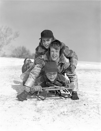 simsearch:846-05646226,k - 1950s THREE BOYS PILED ON TOP OF SLED ON SNOW COVERED HILL OUTDOOR LOOKING AT CAMERA Stock Photo - Rights-Managed, Code: 846-05648522