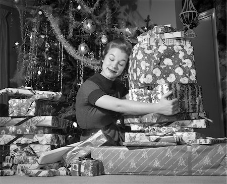 simsearch:846-08030416,k - 1950s WOMAN SITTING BY CHRISTMAS TREE HUGGING PILE OF PRESENTS Stock Photo - Rights-Managed, Code: 846-05648536