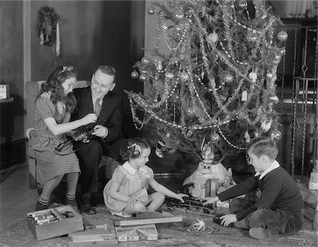 1930s FAMILY CHRISTMAS PHOTO FATHER TWO DAUGHTERS AND SON WITH PRESENTS AND TREE Foto de stock - Con derechos protegidos, Código: 846-05648542