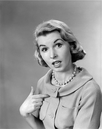 simsearch:846-08030391,k - 1950s WOMAN POINTING TO HERSELF QUIZZICAL EXPRESSION INDOOR Stock Photo - Rights-Managed, Code: 846-06111832