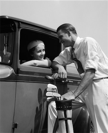 simsearch:846-06112141,k - 1930s WOMAN IN DRIVER'S SEAT OF CAR LEANING OUT OF WINDOW TALKING TO MAN STANDING HOLDING GOLF BAG Stock Photo - Rights-Managed, Code: 846-06111843