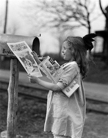 simsearch:846-05646032,k - 1930s 1940s LITTLE GIRL WITH BOW IN HAIR SMILING TAKING MAGAZINES OUT OF RURAL MAILBOX Stock Photo - Rights-Managed, Code: 846-06111953