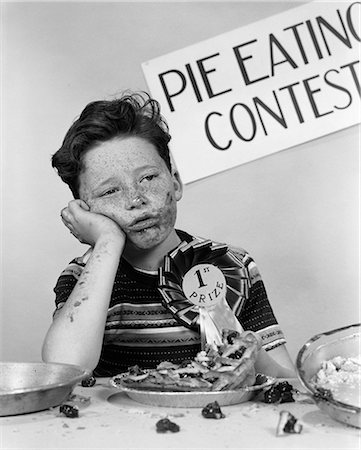 simsearch:846-05645854,k - 1950s BOY WINS 1ST PRIZE AT PIE-EATING CONTEST AND LOOKS SICK Stock Photo - Rights-Managed, Code: 846-06111964