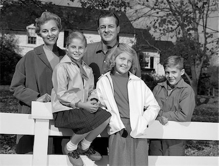 simsearch:846-05648202,k - 1960s PORTRAIT SMILING FAMILY FATHER MOTHER TWO DAUGHTERS SON BY WHITE FENCE IN FRONT OF SUBURBAN HOUSE IN AUTUMN Stock Photo - Rights-Managed, Code: 846-06112004