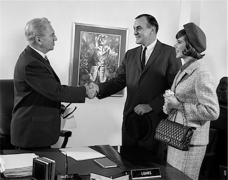 1960s COUPLE HUSBAND AND WIFE SHAKING HANDS WITH BANK LOAN MANAGER BUSINESS INDOOR Stock Photo - Rights-Managed, Code: 846-06112232