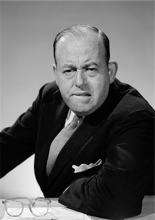 simsearch:846-08639518,k - 1950s 1960s PORTRAIT OF MAN BUSINESSMAN WORRIED UNHAPPY FROWNING LEANING ON DESK LOOKING AT CAMERA Stock Photo - Rights-Managed, Code: 846-06112274