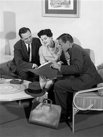 1950s SALESMAN SHOWING FOLDER TO COUPLE AT HOME IN LIVING ROOM Stock Photo - Rights-Managed, Code: 846-06112388