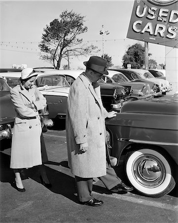 1950s COUPLE IN USED CAR LOT MAN KICKING TIRE Stock Photo - Rights-Managed, Code: 846-07200067