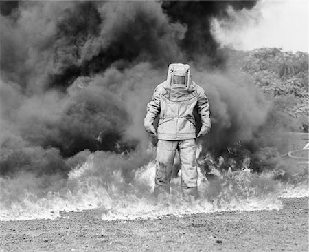 simsearch:846-05645924,k - 1960s FIREMAN IN ASBESTOS SUIT STANDING IN SMOKE AND FLAMES Stock Photo - Rights-Managed, Code: 846-07200080