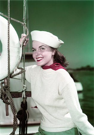 simsearch:846-08030416,k - 1940s PORTRAIT SMILING WOMAN WEARING SAILOR HAT YACHTING OUTFIT POSING BY SAILBOAT RIGGING LOOKING AT CAMERA Stock Photo - Rights-Managed, Code: 846-08030409
