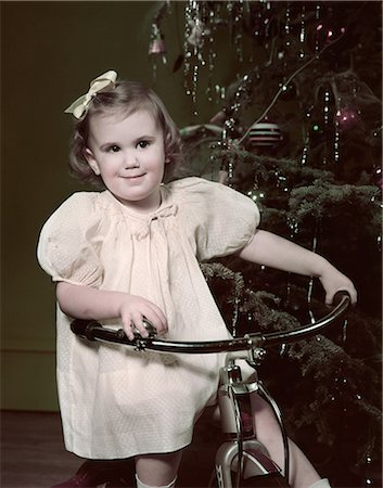 simsearch:846-08030416,k - 1950s SMILING GIRL RIDING TRICYCLE BY CHRISTMAS TREE Stock Photo - Rights-Managed, Code: 846-08030403