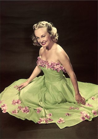 simsearch:846-02791806,k - 1940s 1950s PORTRAIT SMILING BLOND WOMAN SITTING POSING WEARING GREEN FORMAL GOWN DECORATED WITH ORCHIDS LOOKING AT CAMERA Stock Photo - Rights-Managed, Code: 846-08030414