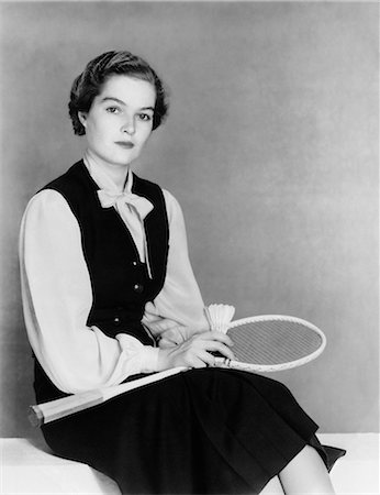 facial - 1940s WOMAN SITTING BENCH HOLDING BADMINTON RACKET & SHUTTLECOCK WEARING A DARK VEST BLOUSE LOOKING AT CAMERA Stock Photo - Rights-Managed, Code: 846-08140040