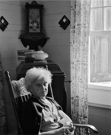 simsearch:846-08030391,k - 1960s SAD LONELY ELDERLY WOMAN SITTING IN ROCKING CHAIR ILLUMINATED BY WINDOW LIGHT Stock Photo - Rights-Managed, Code: 846-08226067