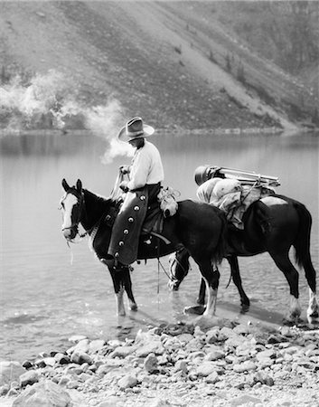 simsearch:846-02793153,k - 1920s 1930s MAN COWBOY ON HORSE WITH PACK HORSE BY MORAINE LAKE ALBERTA CANADA Stock Photo - Rights-Managed, Code: 846-08226096