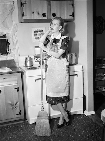 simsearch:846-08030391,k - 1950s TIRED HOUSEWIFE IN APRON STANDING IN FRONT OF STOVE LEANING ON BROOM LOOKING AT CAMERA Stock Photo - Rights-Managed, Code: 846-08226102