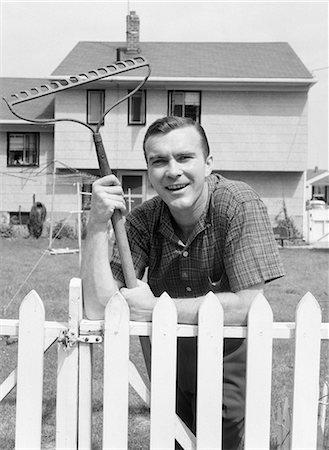 photo picket garden - 1950s MAN IN PLAID SHIRT IN BACKYARD LEANING ON WHITE PICKET FENCE WITH RAKE IN HAND Stock Photo - Rights-Managed, Code: 846-08226174