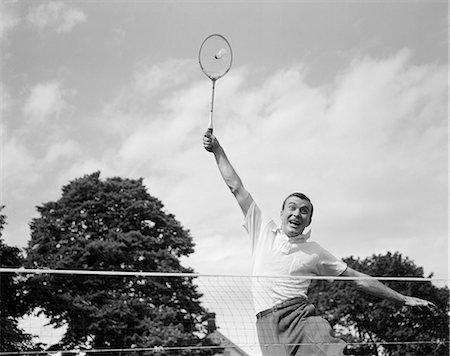 funny man - 1950s 1960s MAN PLAYING BADMINTON JUMPING UP ARM EXTENDED RACQUET ABOUT TO HIT SHUTTLECOCK BIRDIE WACKY FUNNY EXTREME EFFORT LOB Stock Photo - Rights-Managed, Code: 846-08226173