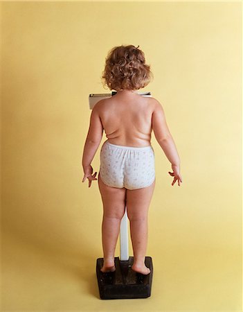 sad girls - 1970s OVERWEIGHT CHUBBY LITTLE GIRL WEIGHING HERSELF ON SCALE BACK VIEW WEARING ONLY PANTIES Foto de stock - Con derechos protegidos, Código: 846-08512708