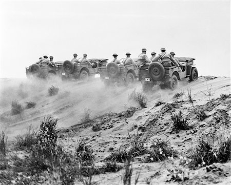 simsearch:846-05645924,k - 1940s ARMY SOLDIERS RIDING JEEPS IN FORMATION GOING UP A DUSTY HILL Stock Photo - Rights-Managed, Code: 846-09012674