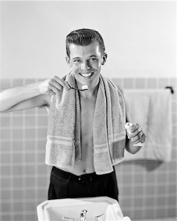 1950s SMILING TEENAGED BOY STANDING AT BATHROOM SINK BRUSHING TEETH LOOKING AT CAMERA Photographie de stock - Rights-Managed, Code: 846-09012698