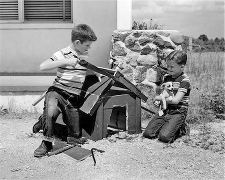 retro suburban house - 1950s 1960s TWO BOYS BUILDING DOG HOUSE FOR THEIR NEW PUPPY DOG Stock Photo - Rights-Managed, Code: 846-09012724