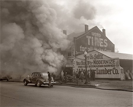 simsearch:846-05645898,k - 1940s SMOKE AND FIRE BILLOWING OUT OF A BURNING INDUSTRIAL COMMERCIAL BUILDING Stock Photo - Rights-Managed, Code: 846-09012737