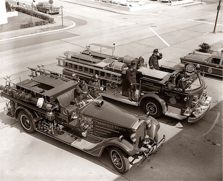 emergency alarm - 1950s 1960s TOP VIEW OF TWO FIRE TRUCKS PARKED AT STATION FIREMEN ON TRUCK WEARING PROTECTIVE EQUIPMENT Stock Photo - Rights-Managed, Code: 846-09012738