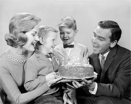 1960s  FAMILY AROUND A BIRTHDAY CAKE CANDLES SINGING TO BOY Stock Photo - Rights-Managed, Code: 846-09012796